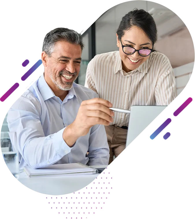 A man and woman smiling while the man points to something on his laptop screen