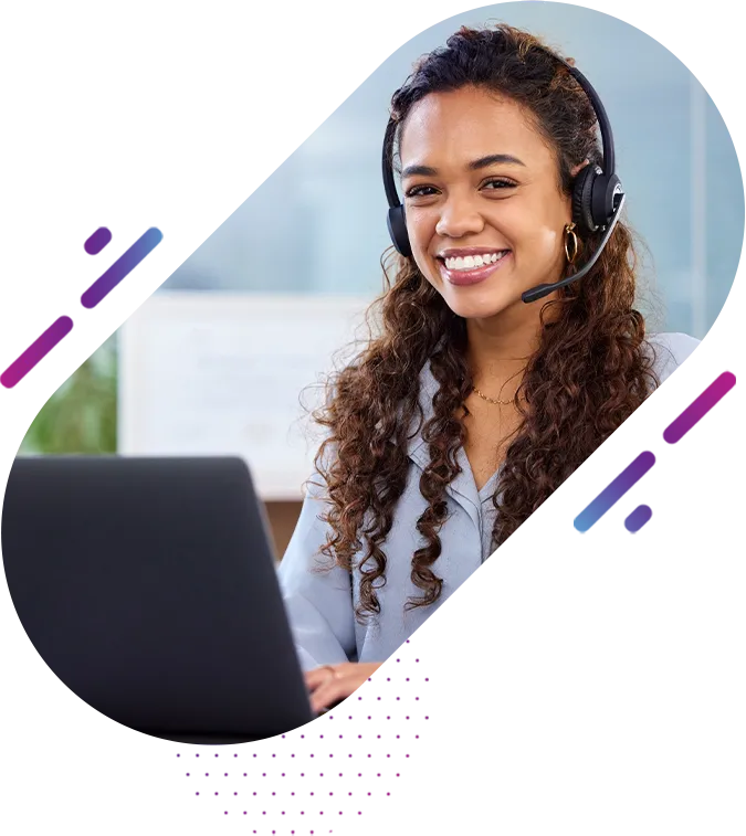 a woman smiles at the camera while sitting behind her laptop with a headset on